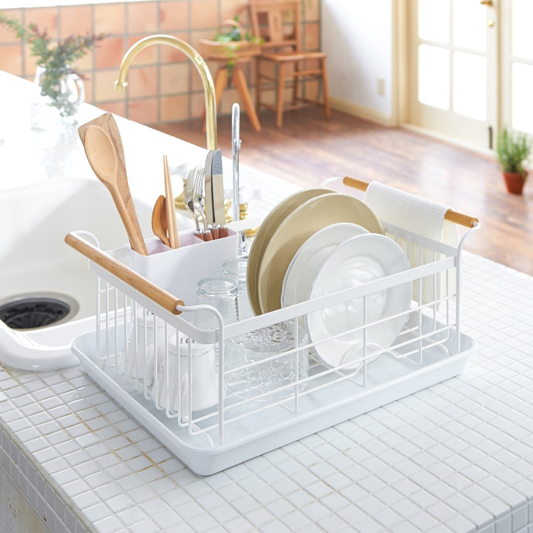 2.Dish rack holding plates, utensils, and cups on kitchen sink countertop by Yamazaki Home. 