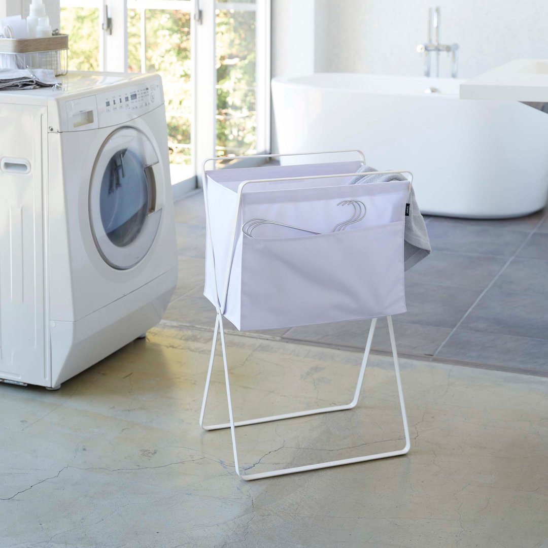 Laundry hamper elevated above floor by steel frame in sleek kitchen