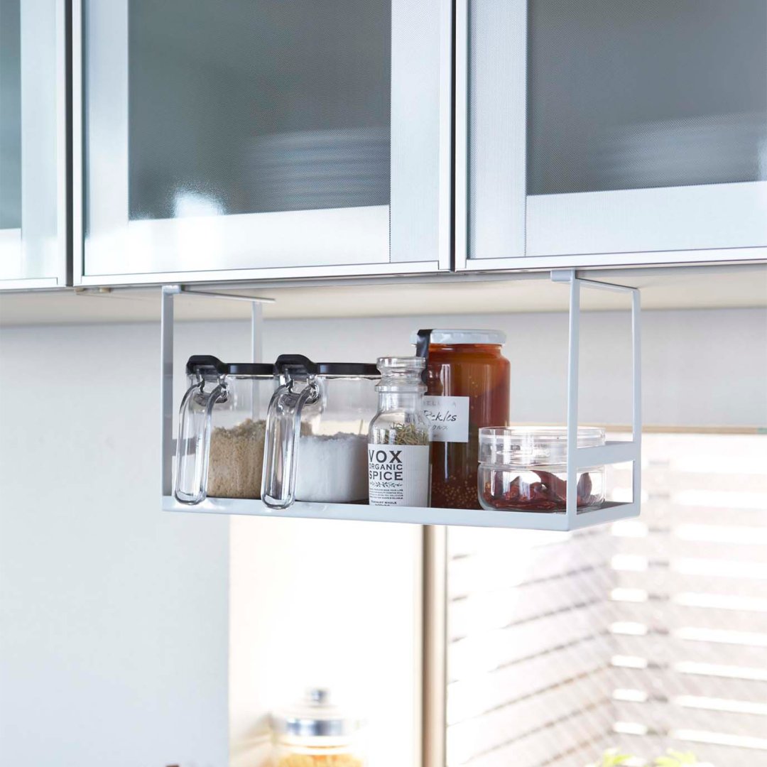 Yamazaki Home white Undershelf Organizer hanging on a shelf.