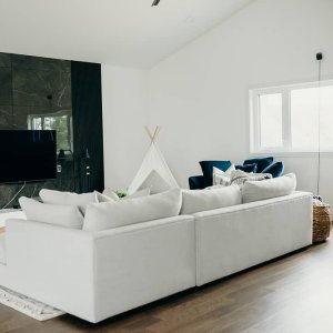 Mixing wood slats with tile created the perfect backdrop for hiding the TV but at the same time becoming a feature. Love the sleek modern lines from this view 🤍
📸: brittneyjunephotography 
Tile: Liliidae Home and Design
Sectional: urbanbarn 
Rug: Liliidae Home and Design
Teepee: amazon 
TV Console: roveconcepts