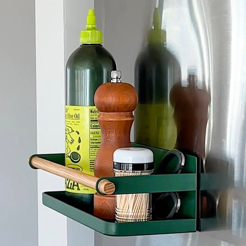 Forest Green Magnetic Caddy shown with olive oil, a pepper grinder, and tooth picks