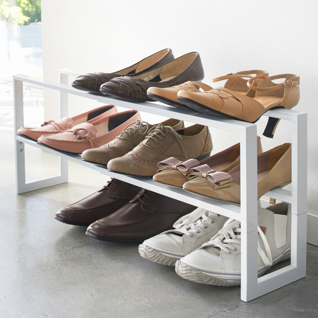 two tier expandable shoe rack with various pairs of shoes in modern home