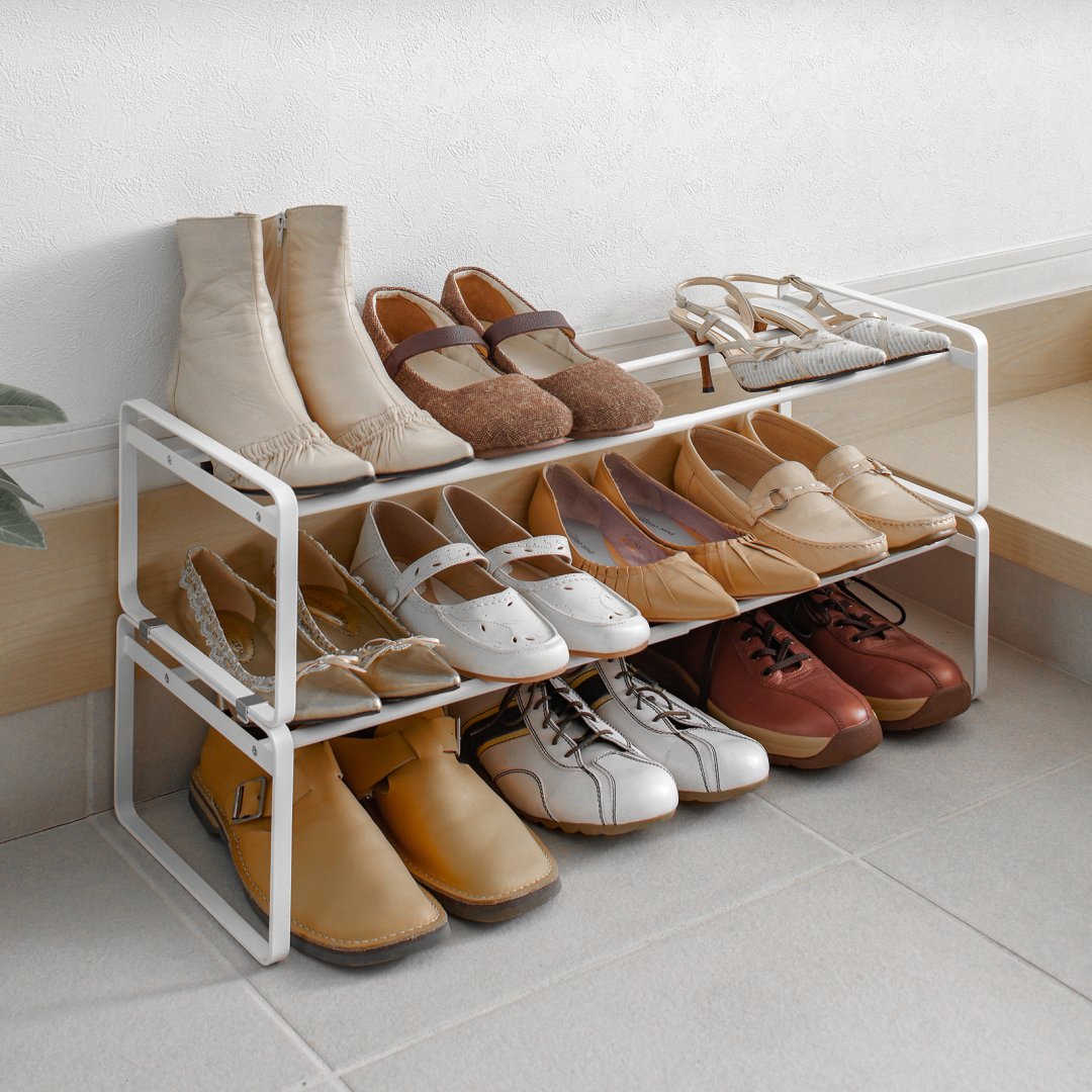 Stackable shoe rack placed in entryway with multiple pairs of shoes